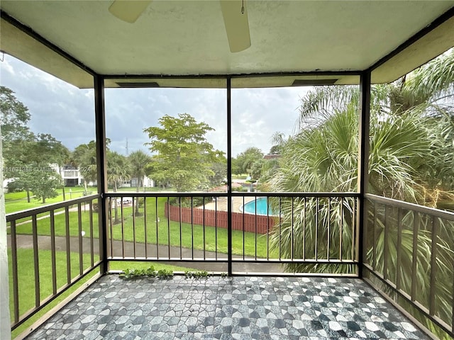 unfurnished sunroom featuring ceiling fan