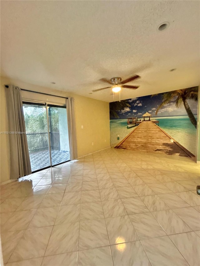 empty room featuring ceiling fan and a textured ceiling