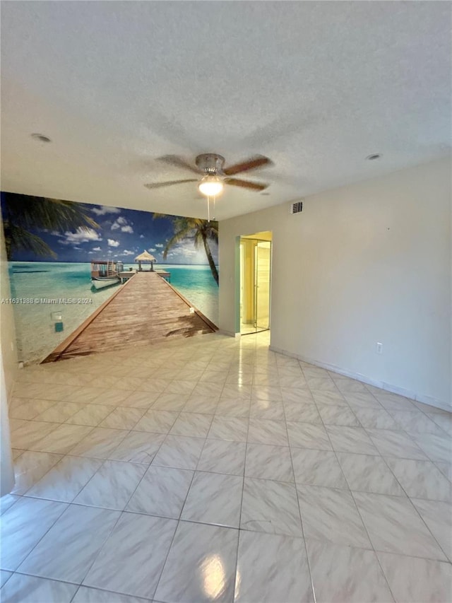 unfurnished room featuring a textured ceiling and ceiling fan