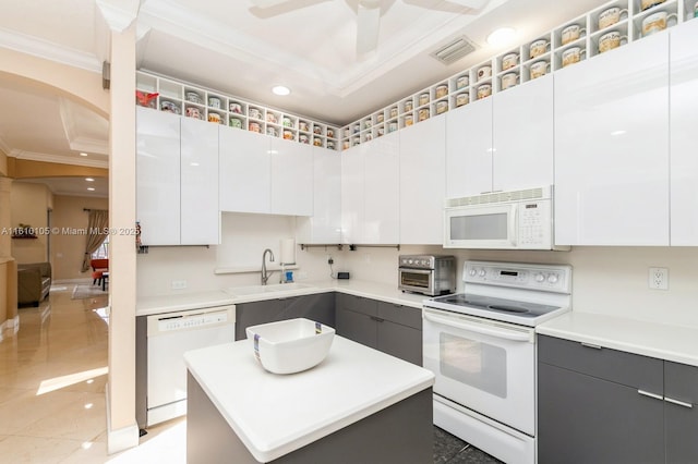 kitchen with sink, white appliances, white cabinets, and a kitchen island