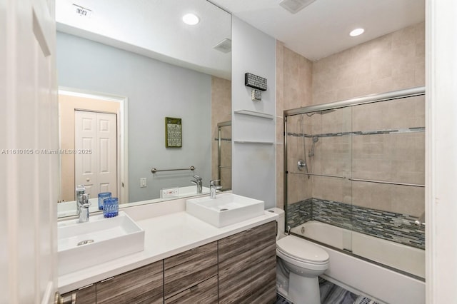 full bathroom with toilet, vanity, and bath / shower combo with glass door