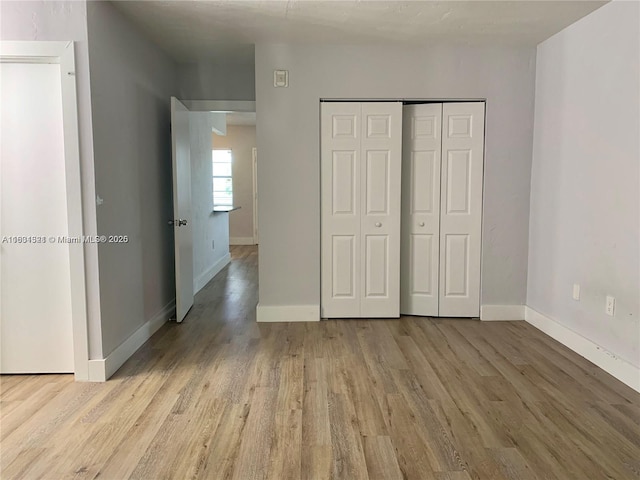 unfurnished bedroom with a closet and light hardwood / wood-style flooring