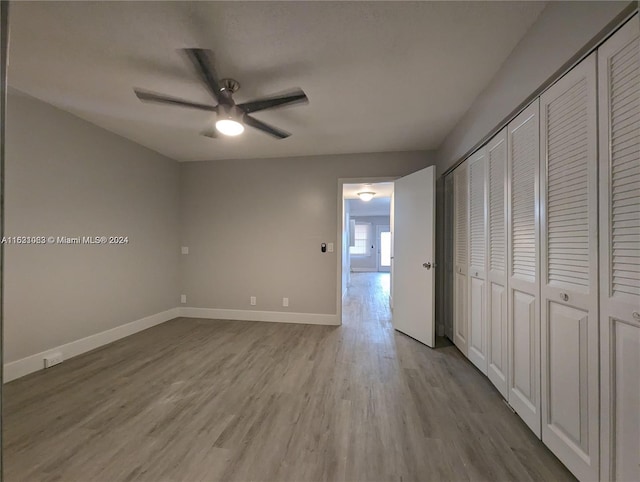 unfurnished bedroom featuring a closet, hardwood / wood-style flooring, and ceiling fan