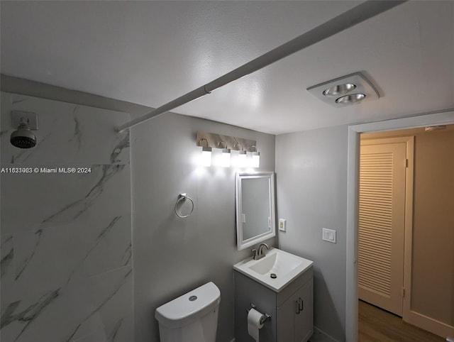 bathroom featuring vanity, toilet, hardwood / wood-style flooring, and walk in shower