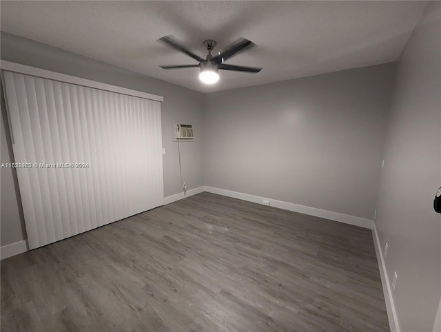 unfurnished room featuring a wall unit AC, ceiling fan, and hardwood / wood-style flooring