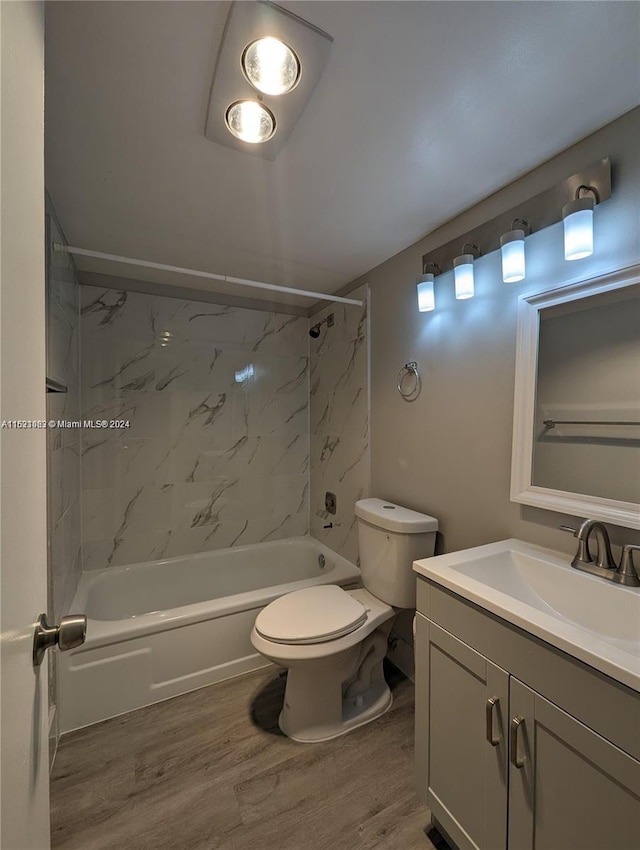 full bathroom featuring vanity, wood-type flooring, tiled shower / bath, and toilet