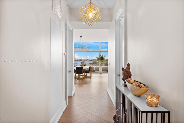 hallway with an inviting chandelier and parquet flooring