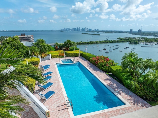 view of pool with a water view and a patio area