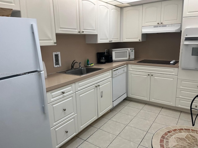 kitchen featuring sink, white appliances, light tile patterned floors, and white cabinetry