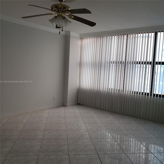 tiled spare room featuring ornamental molding and ceiling fan