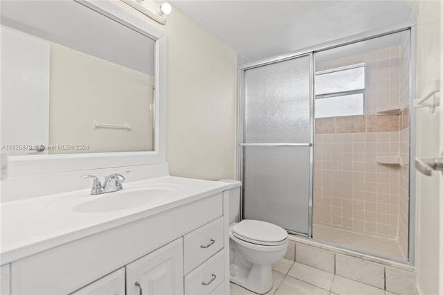 bathroom with toilet, a stall shower, tile patterned flooring, and vanity