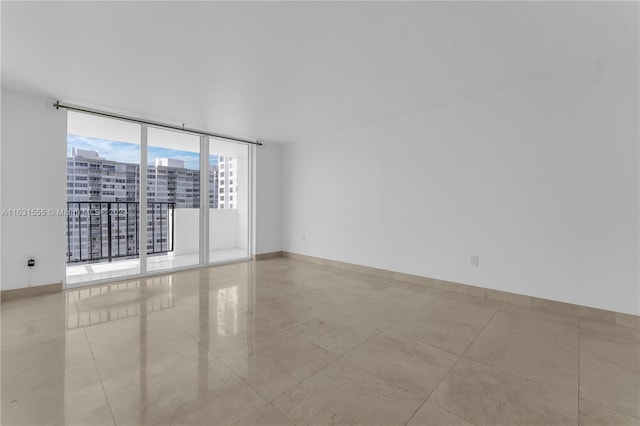 empty room featuring light tile patterned flooring and floor to ceiling windows