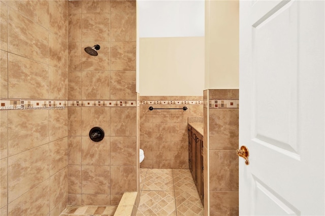 bathroom featuring vanity, a tile shower, and toilet