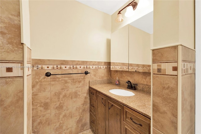 bathroom featuring vanity and tile walls