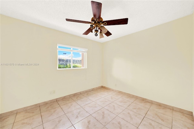 unfurnished room with light tile patterned flooring, a textured ceiling, and ceiling fan