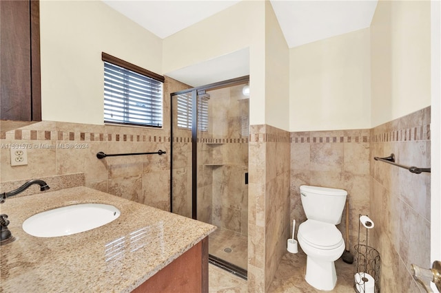 bathroom with tile walls, tile patterned floors, toilet, and vanity