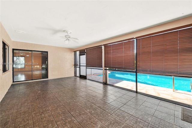 tiled empty room featuring ceiling fan