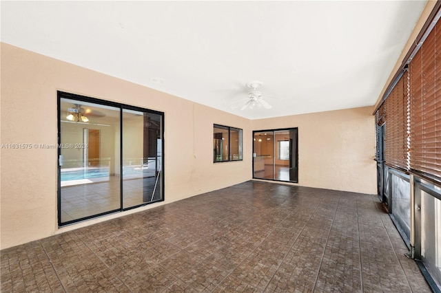 spare room featuring dark tile patterned flooring and ceiling fan