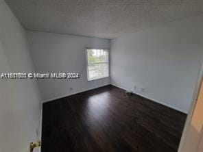 empty room with dark hardwood / wood-style flooring