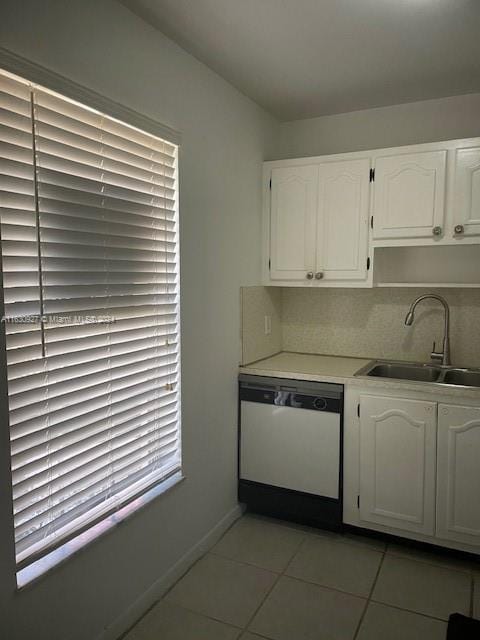 kitchen featuring dishwasher, white cabinetry, sink, and light tile patterned flooring