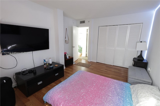 bedroom with dark wood-type flooring and a closet