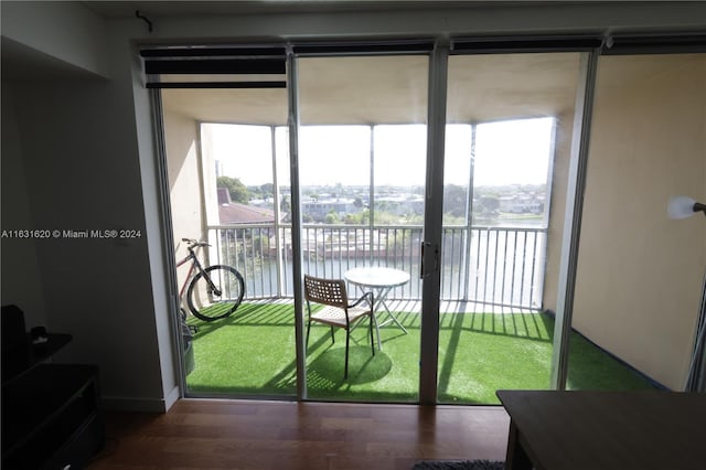 doorway with plenty of natural light, a water view, and hardwood / wood-style flooring