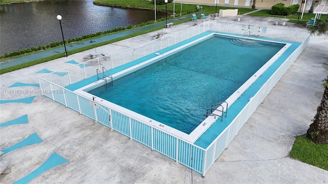 view of swimming pool with a water view and a patio area