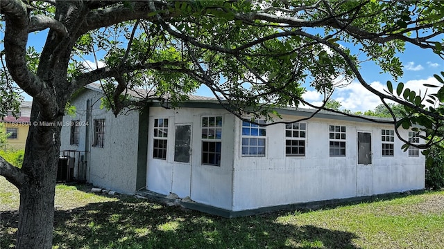 view of property exterior featuring central air condition unit and a lawn