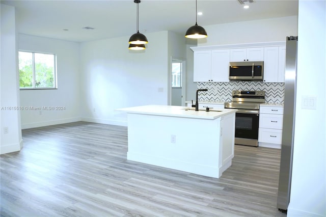 kitchen with white cabinetry, light wood-type flooring, stainless steel appliances, decorative backsplash, and sink