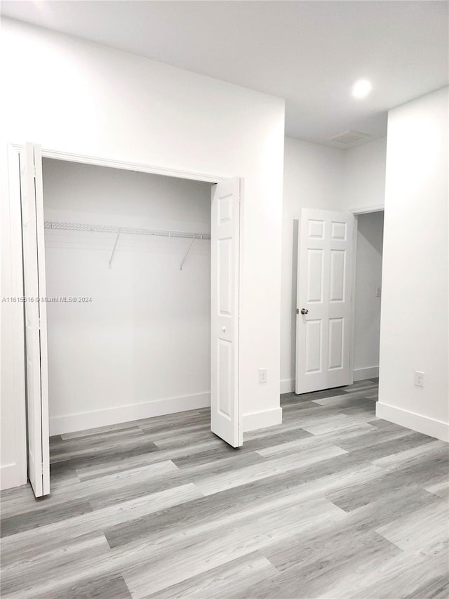 unfurnished bedroom featuring a closet and light wood-type flooring