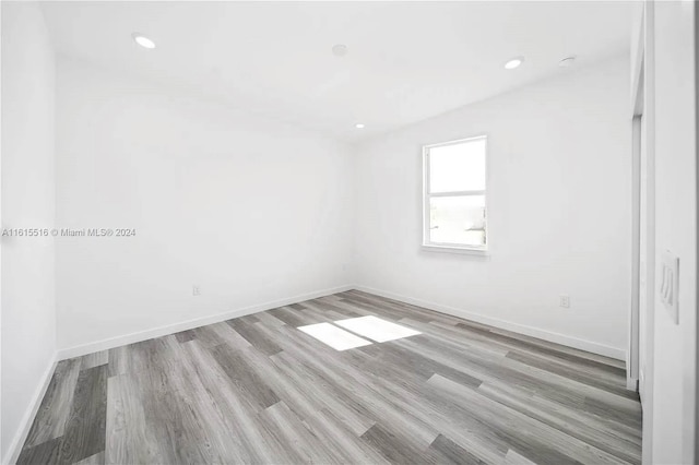 unfurnished room with wood-type flooring and lofted ceiling