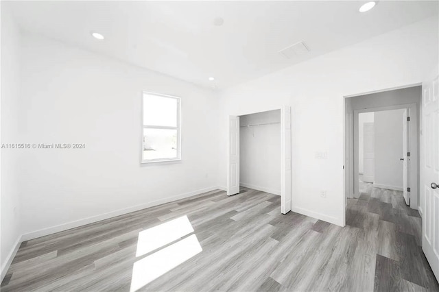 unfurnished bedroom featuring hardwood / wood-style flooring and a closet