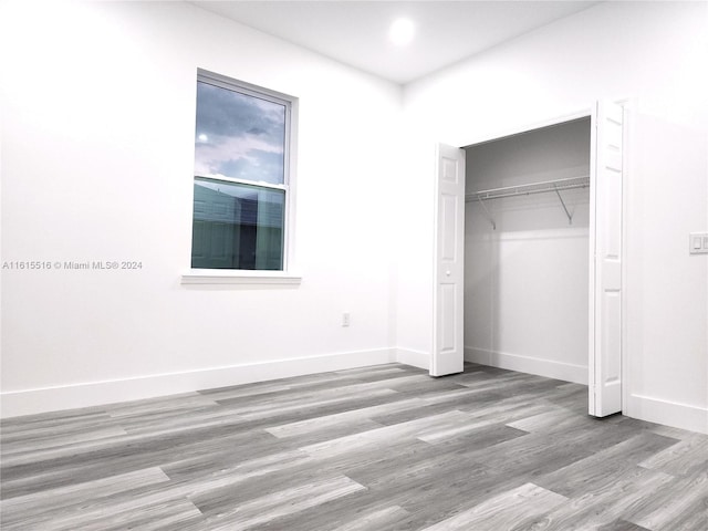 unfurnished bedroom featuring hardwood / wood-style flooring and a closet