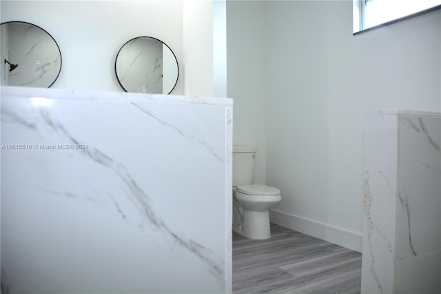 bathroom with toilet and hardwood / wood-style floors