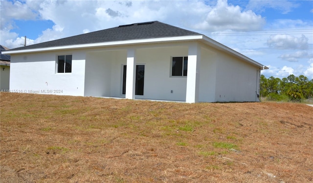 rear view of house featuring a yard