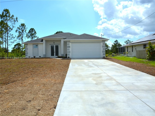 view of front of property featuring a garage, solar panels, and a front lawn