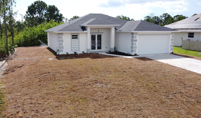 ranch-style home featuring french doors, a garage, and solar panels