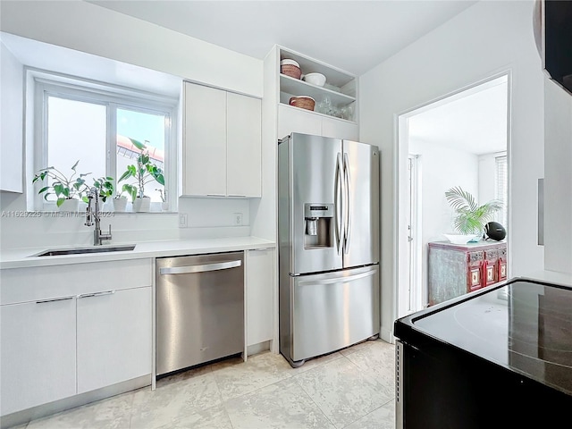 kitchen featuring white cabinets, stainless steel appliances, light tile patterned flooring, and sink