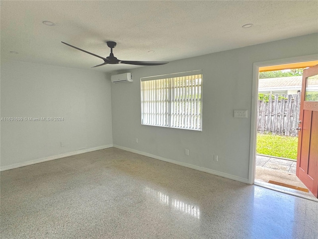 spare room featuring a textured ceiling, a wall mounted air conditioner, and ceiling fan