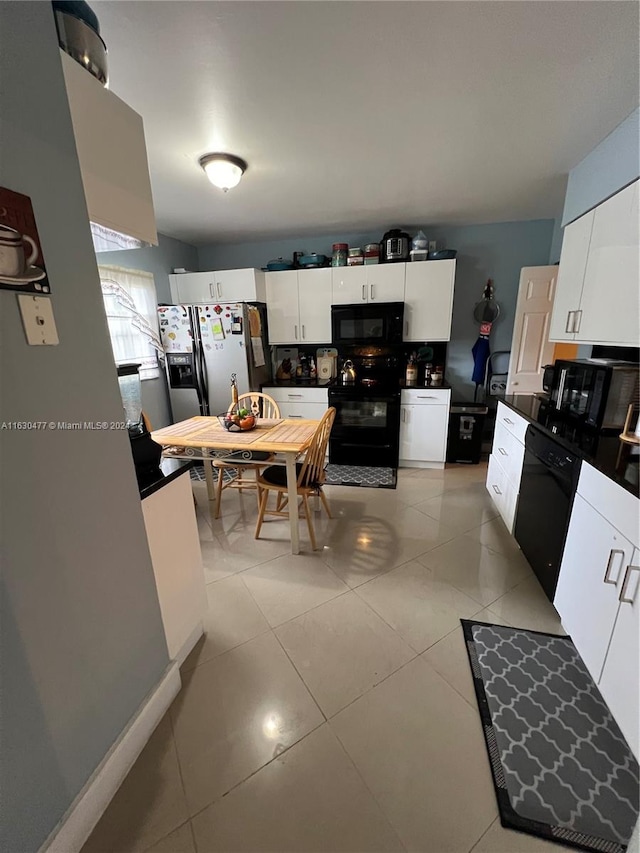 kitchen featuring light tile patterned flooring, white cabinetry, and black appliances