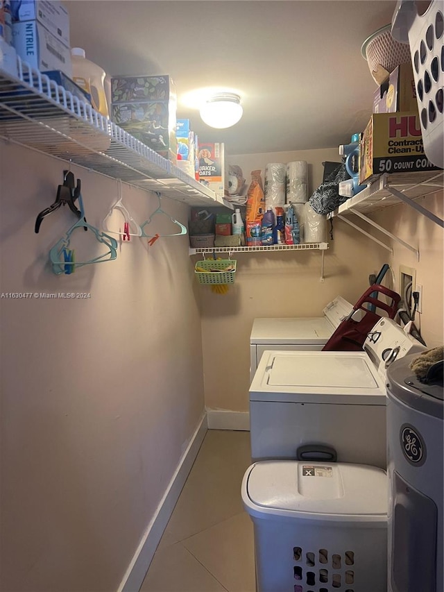 clothes washing area with tile patterned floors and washer and dryer