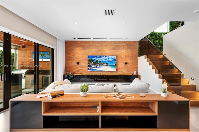 living room with brick wall, rail lighting, and french doors