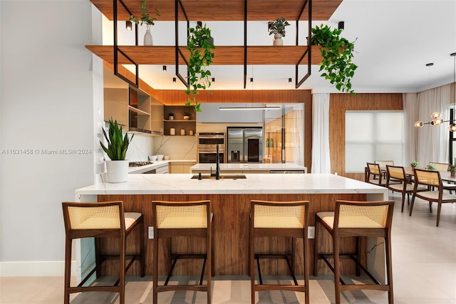 kitchen with pendant lighting, kitchen peninsula, light tile patterned floors, and a breakfast bar