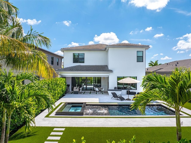 rear view of house featuring a patio area, a pool with hot tub, and a yard