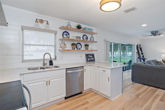 kitchen featuring white cabinets, black range oven, sink, stainless steel dishwasher, and light stone counters