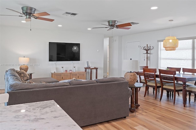 living room with ceiling fan and light wood-type flooring