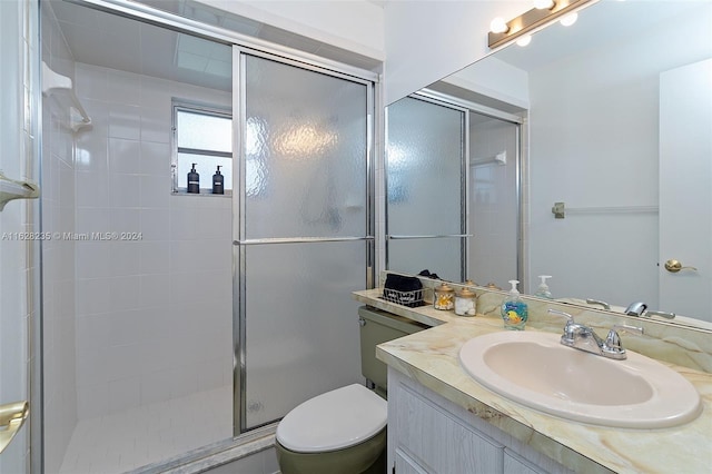 bathroom featuring vanity, toilet, and a shower with door