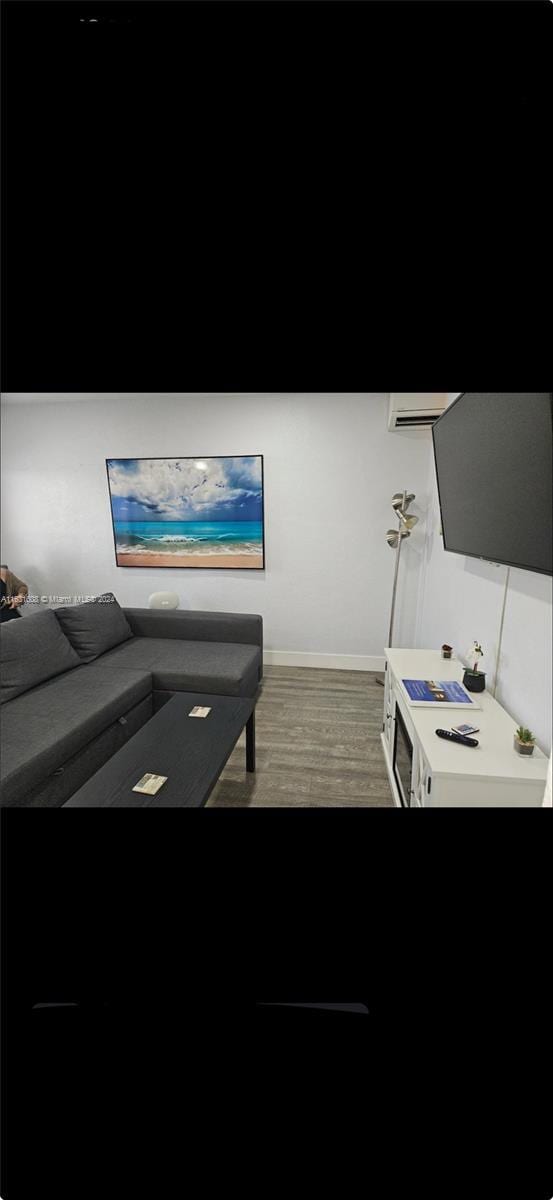 living area with dark wood-type flooring and baseboards