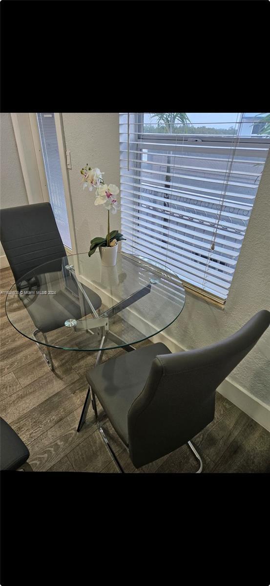 dining space featuring a textured wall and wood finished floors