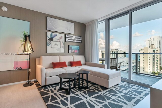 living room with a water view, hardwood / wood-style flooring, and a wall of windows